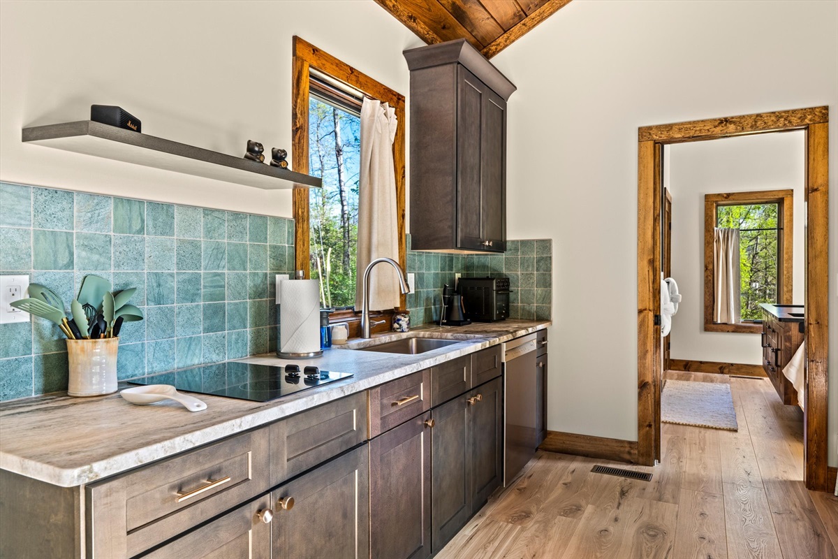 Kitchen with 2 burner cooktop and full-sized dishwasher with custom granite countertop