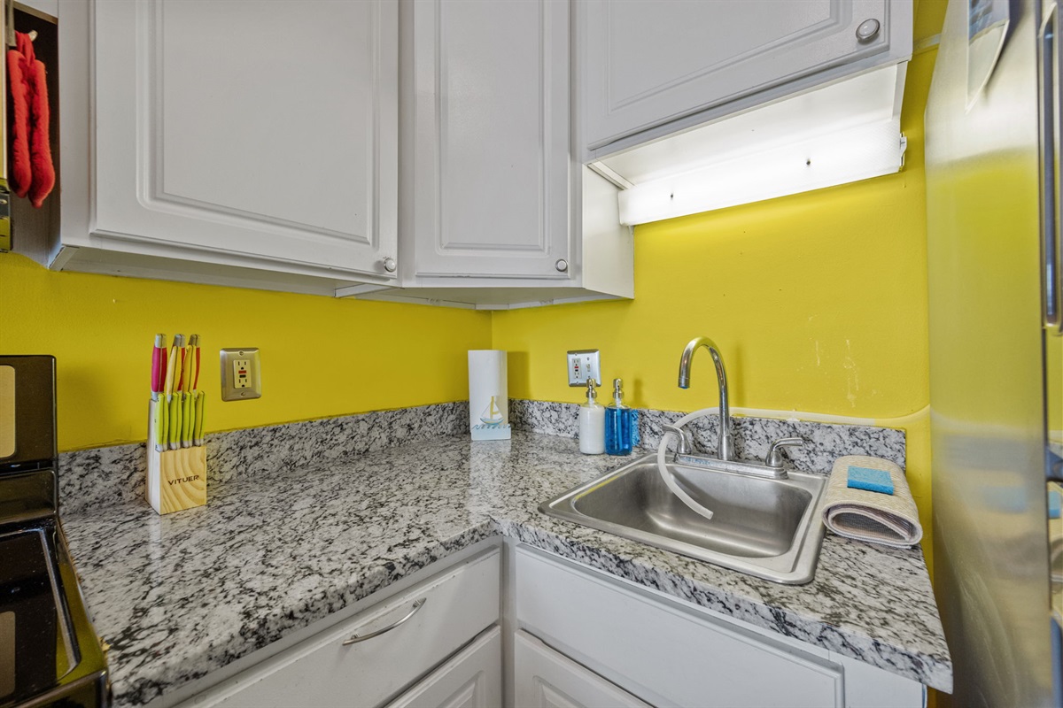 Clean and functional kitchen corner with sink, prep space, and essential cooking tools ready to go