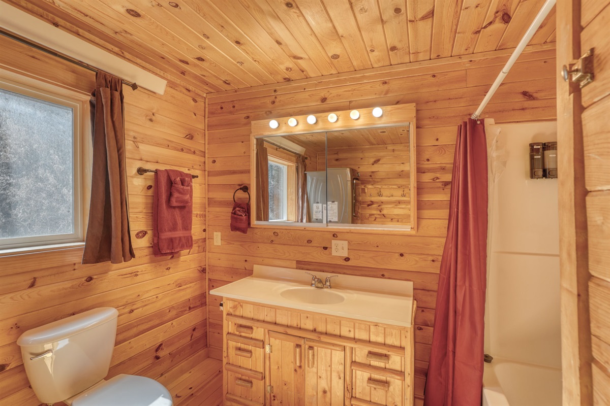Bathroom with bath and washer and drier