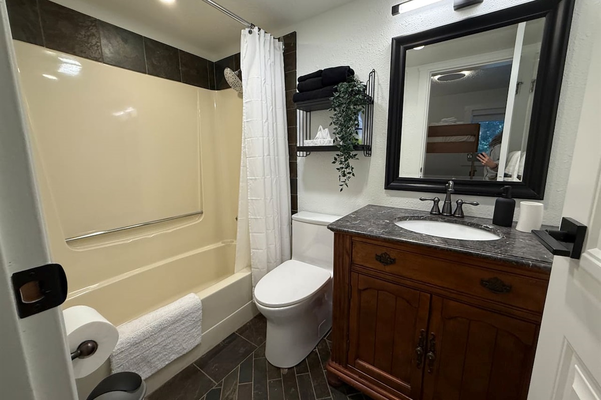 Main Floor Bathroom Details: A clean and functional space with a new comfort-height toilet and convenient shelving to keep toiletries organized.