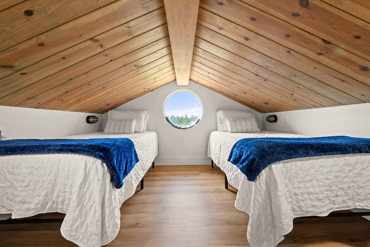 This cozy sleeping nook with twin beds feels tucked away and inviting, making it a comfortable spot to wind down at the end of the day.