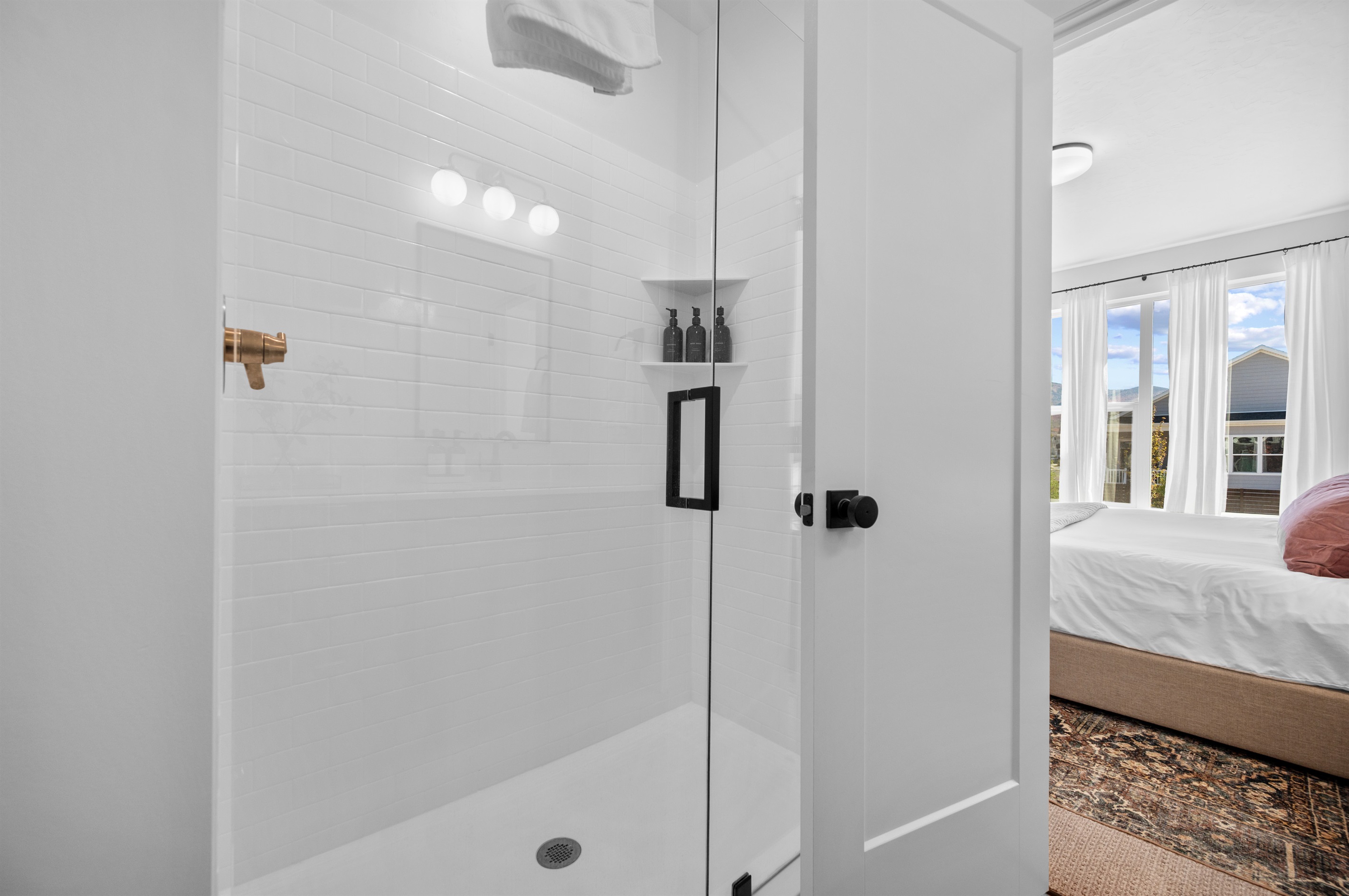 Bright walk-in shower with glass doors offering a refreshing retreat after a day outdoors.
