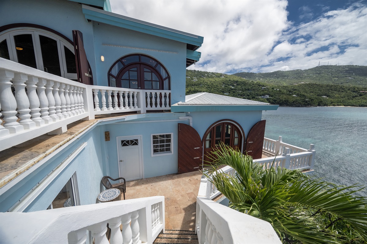 Lounge on the terrace as local fishing boats glide across the bay. This is a second staircase off of the primary bedroom hot tub deck that leads to the pool level. The 3 doors from left to right are: the shared bathroom, pool bedroom 2 and pool bedroom 1