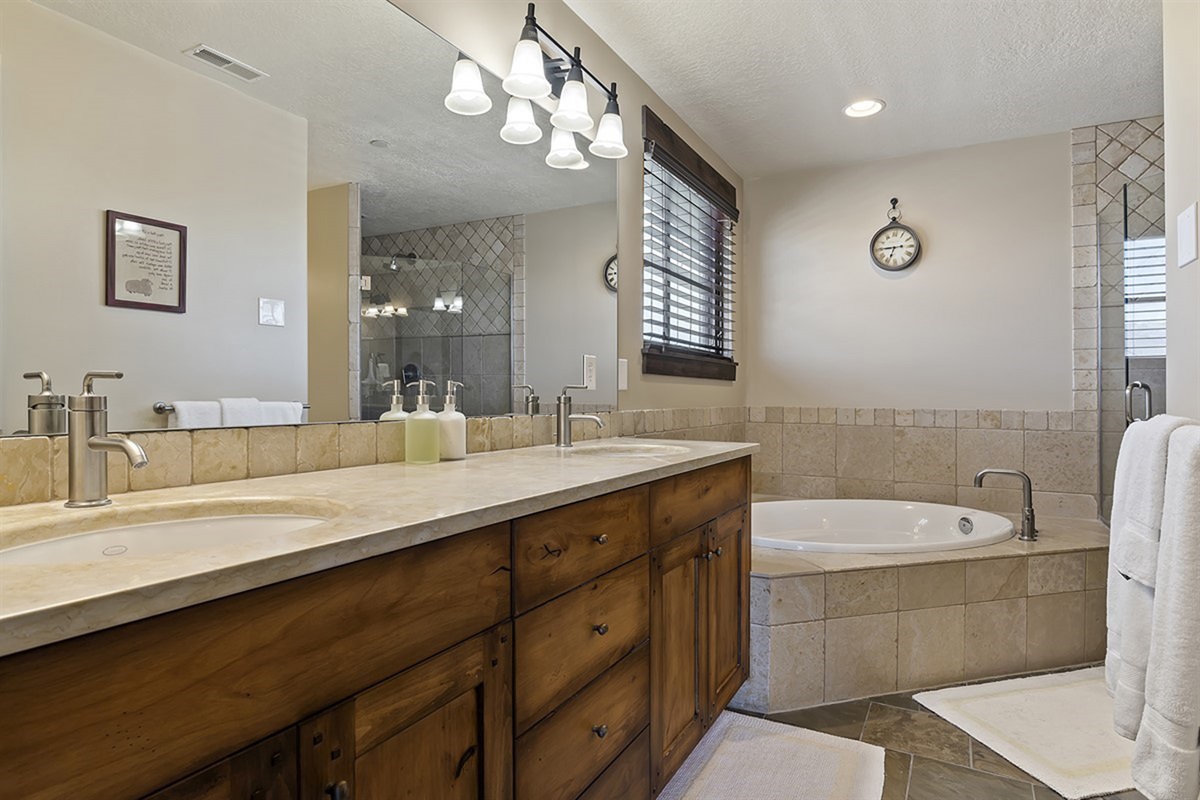 A spa-inspired primary bathroom boasting a double vanity, sleek surfaces, and ample space—perfect for a refined daily routine or relaxing after the days adventures.