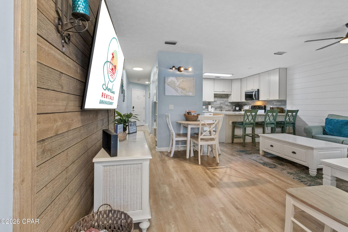 Bright coastal living space perfect for relaxing after a beach day! Enjoy comfortable seating, Smart TV entertainment, and an open layout designed for family time.