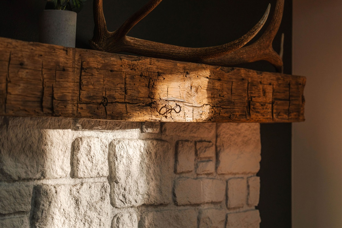 Rustic Fireplace Mantel with Authentic Farmhouse Character. Warm textures and natural light highlight the home’s cozy mountain charm.