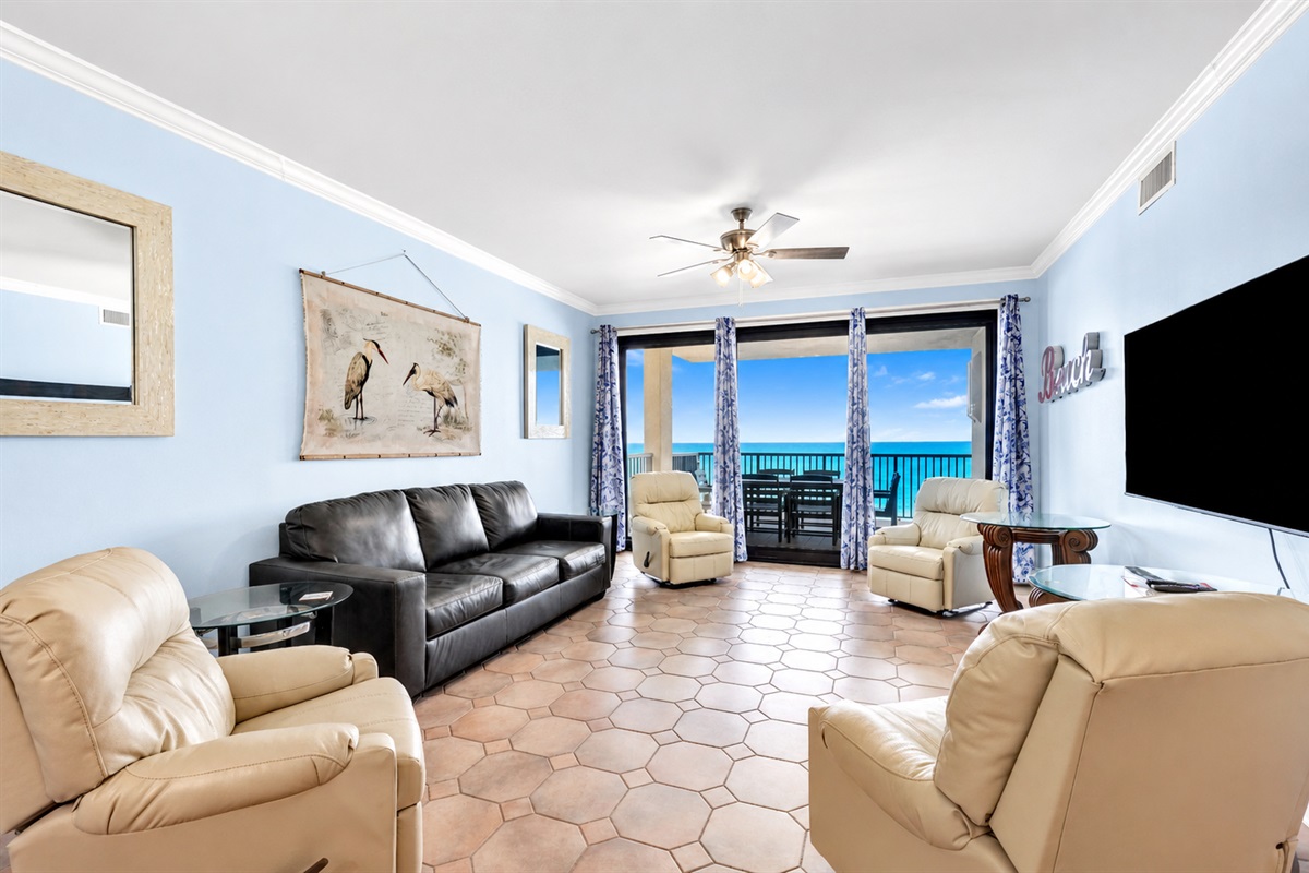Living room with leather sleeper sofa, 4 rocking recliners, 65" wall mounted TV, breathtaking view and balcony access