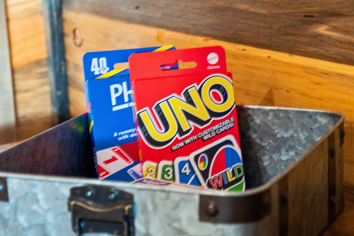 A metallic container reveals a collection of popular card games, including UNO and Phase 10, offering guests a variety of leisure activities.