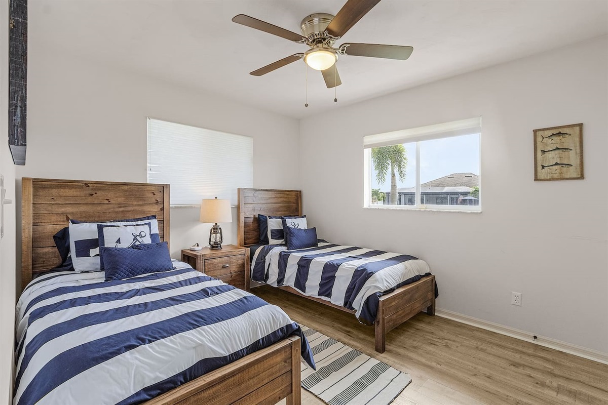 Second guest bedroom with coastal charm — 2 twin beds, TV, and a view of the water!