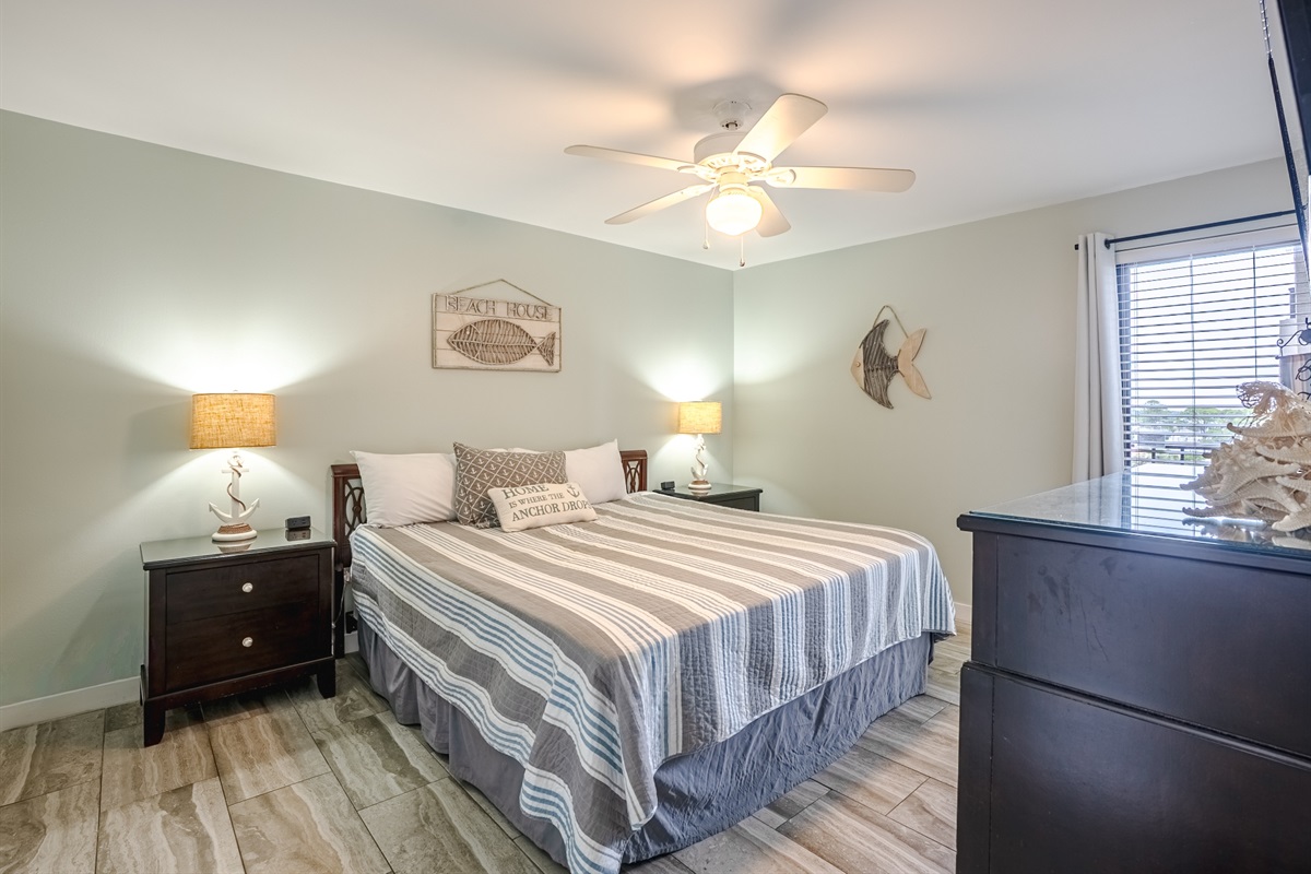 Master bedroom with king bed, ceiling fan, smart TV and ensuite bathroom