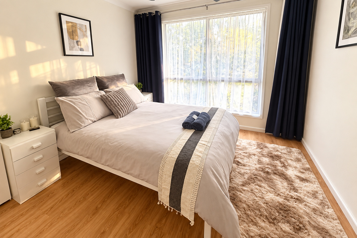 The queen bedroom at Carlenes Getaway has natural light, a ceiling fan and simple comfort for a restful Loch Sport stay.