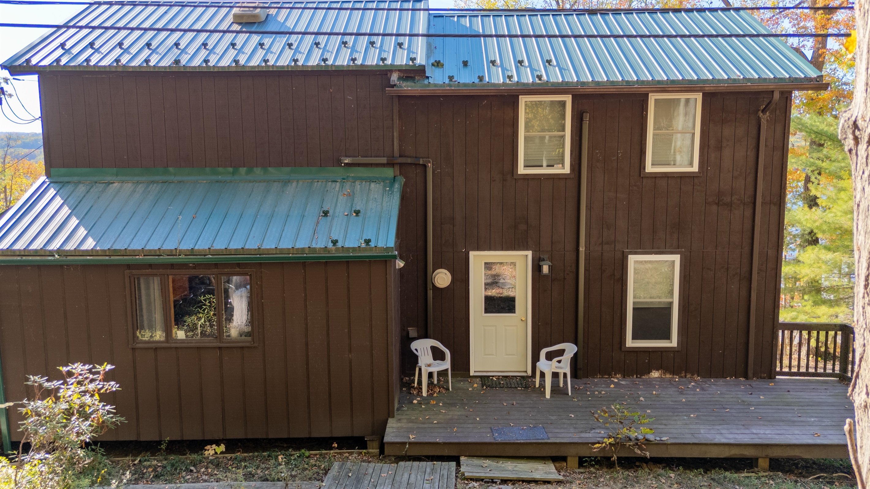 Rear exterior showing large vertical windows and deck access from main floor.