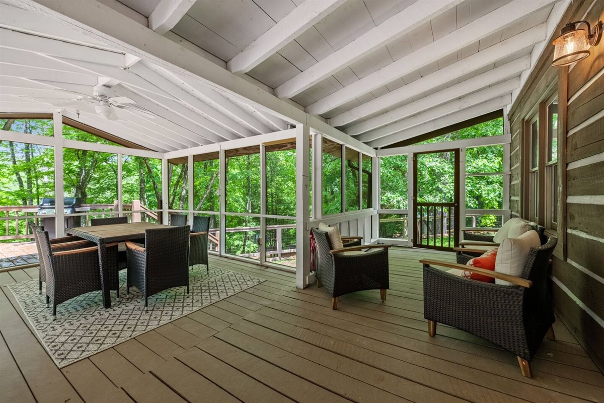 Covered porch with dining table and sitting chairs.