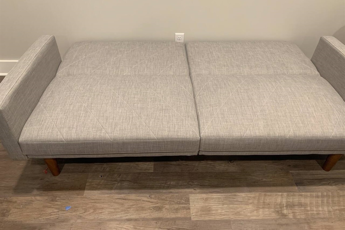 Sleeper sofa in living room folded flat