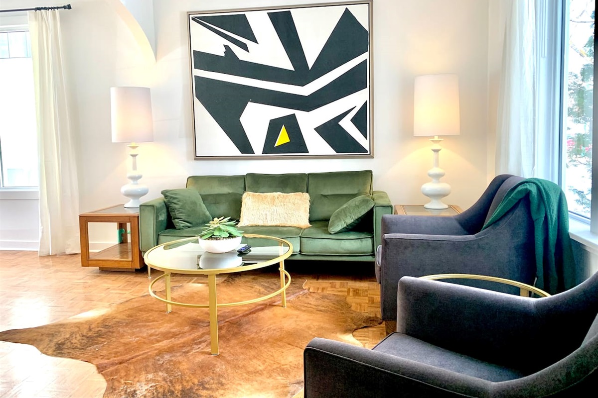 Main-floor living room with original hardwood floors, comfortable seating for 5, and natural light.