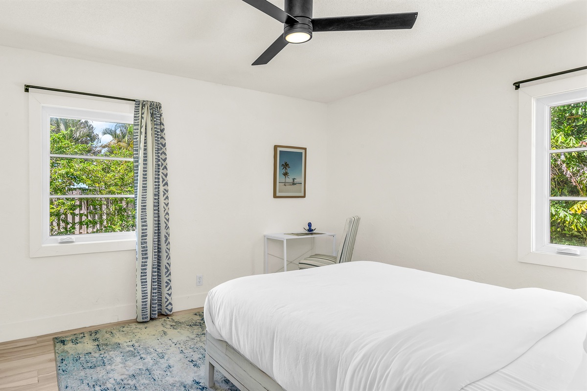Bedroom 3 features bright coastal decor, crisp white linens, and pops of ocean blue- creating a serene and cheerful retreat for guests to relax and unwind in comfort.