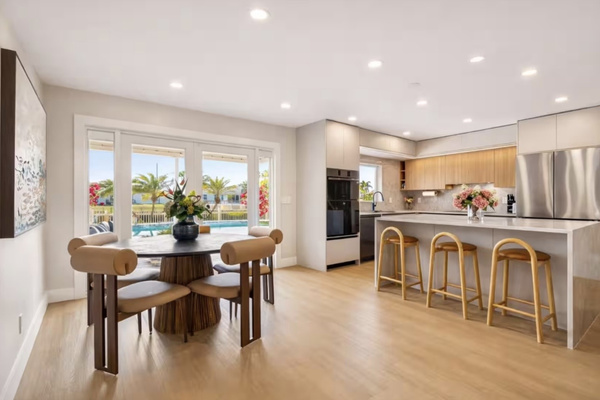 Open-concept dining and kitchen area with views of the pool.