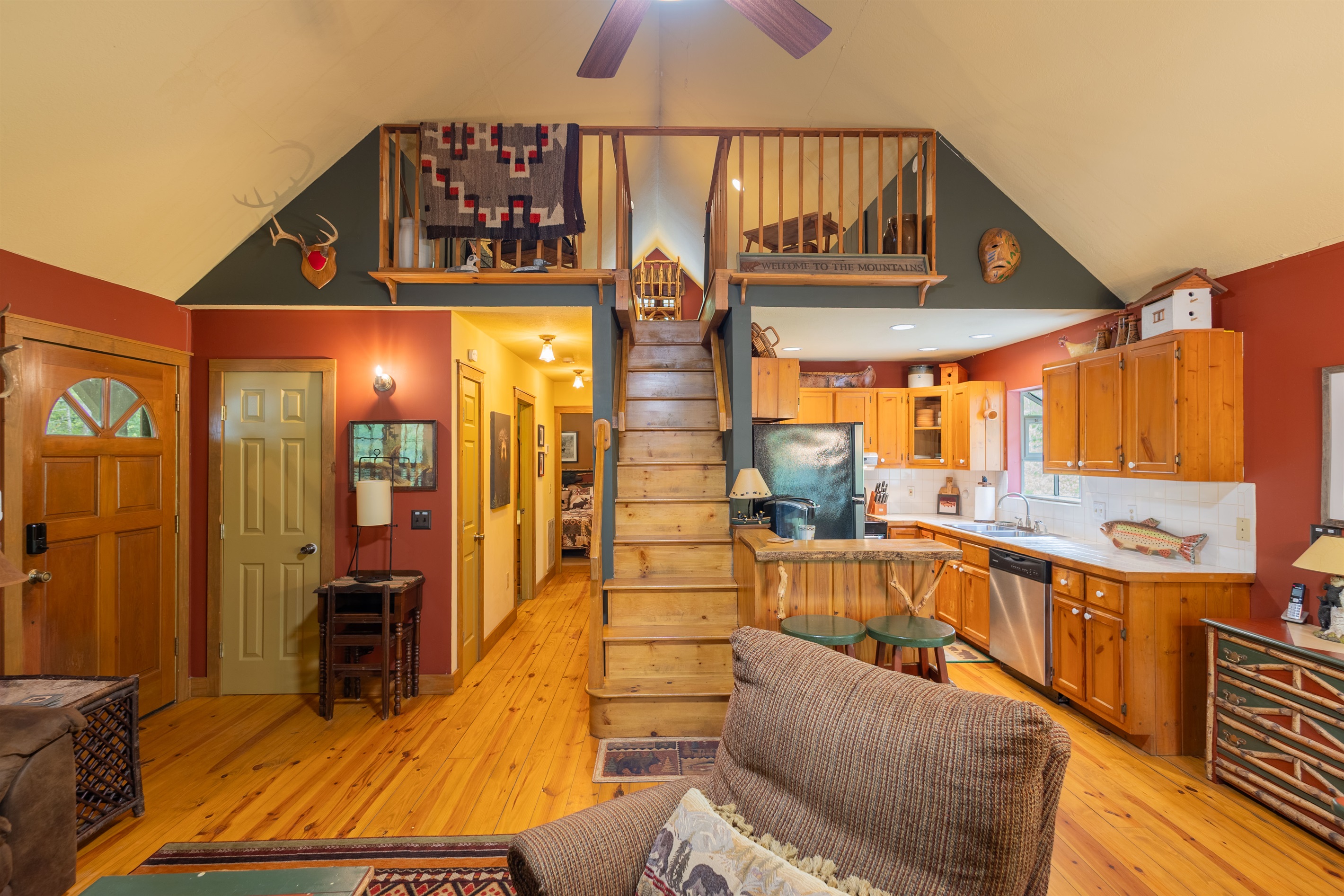 From the center of the living room, the open layout connects seamlessly to the loft, kitchen, and hallway areas above and beyond.