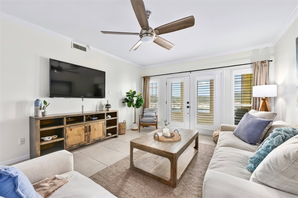 Open living area with a large TV, cozy seating, and easy access to the balcony for indoor-outdoor relaxation.