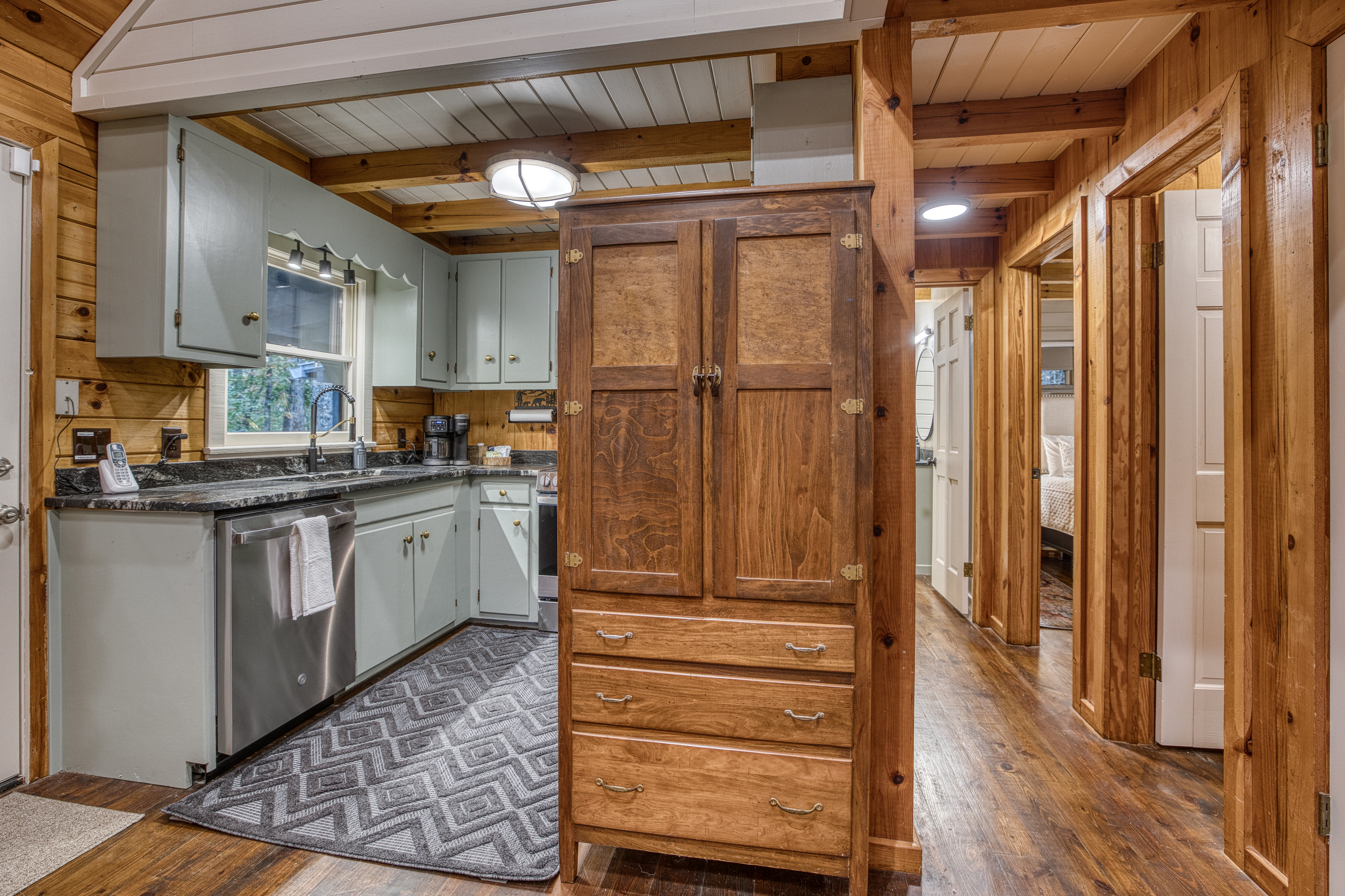 Kitchen and hallway with a wood armoire.