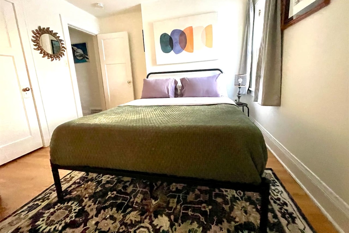 Comfortable queen bed with soft linens and calming décor, designed for a restful night’s sleep.