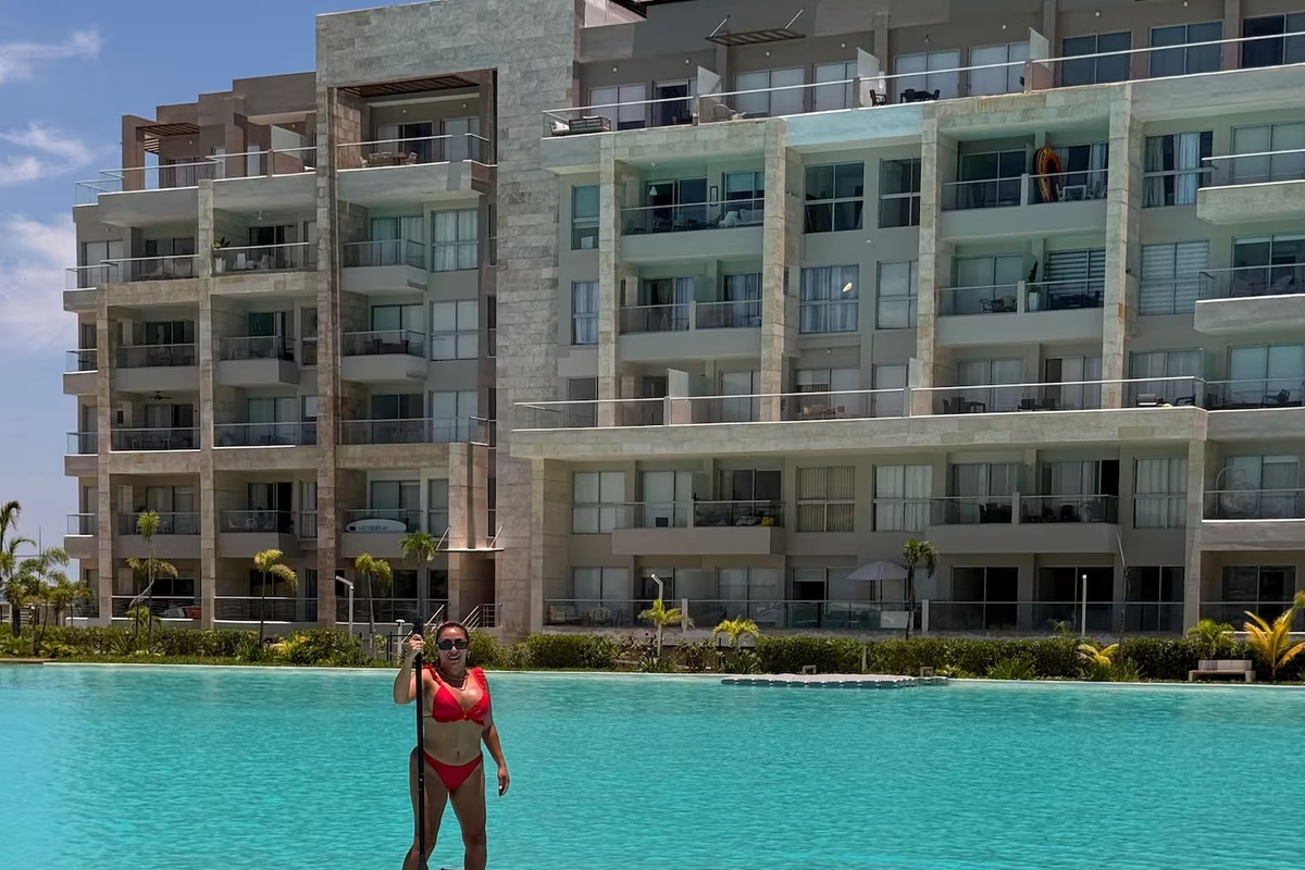 Piscina compartida estilo laguna con amplia zona para nadar y entorno tipo resort, ofreciendo a los huéspedes un espacio cómodo para refrescarse al aire libre.