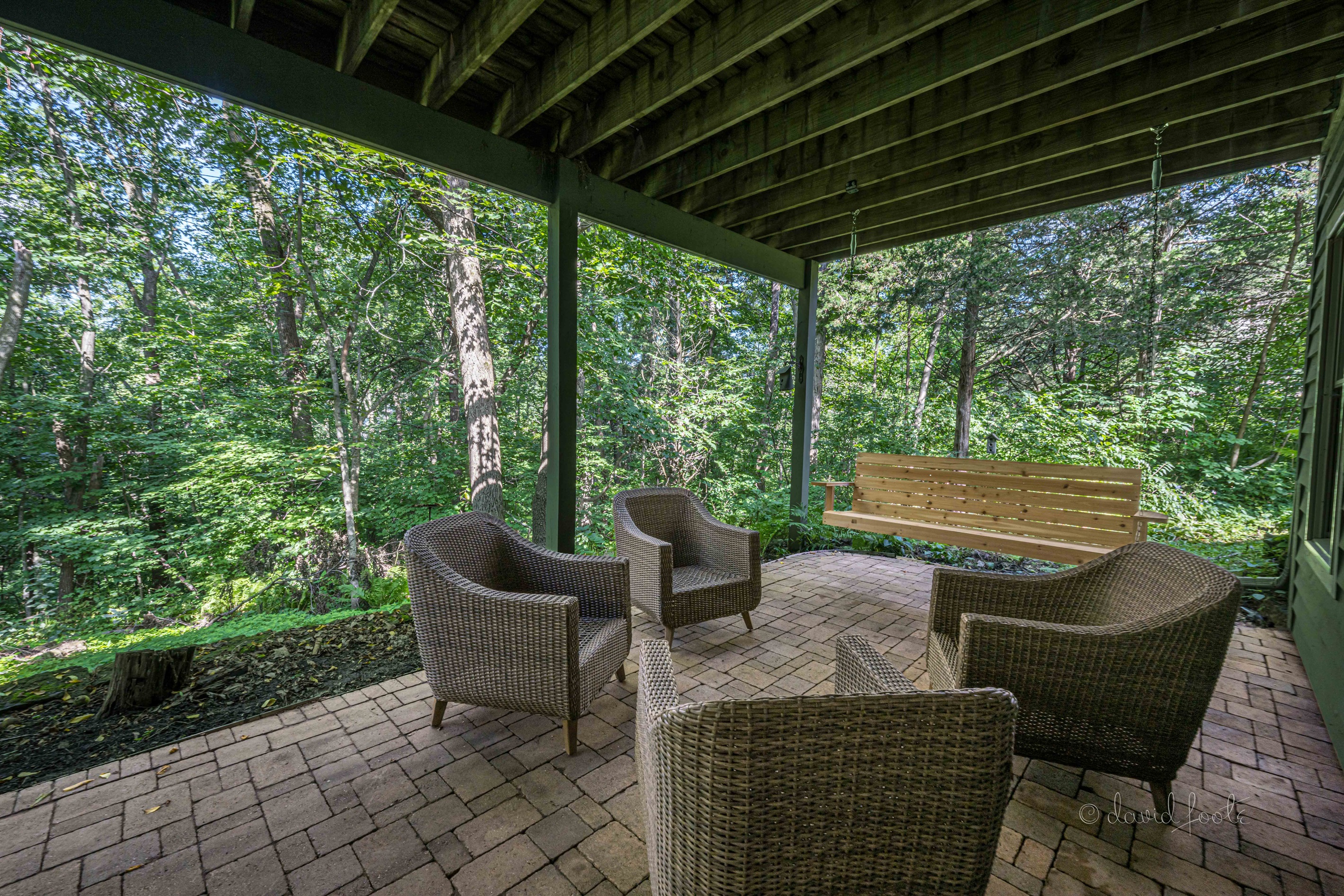 Covered patio with gas fire table, seating, and porch swing