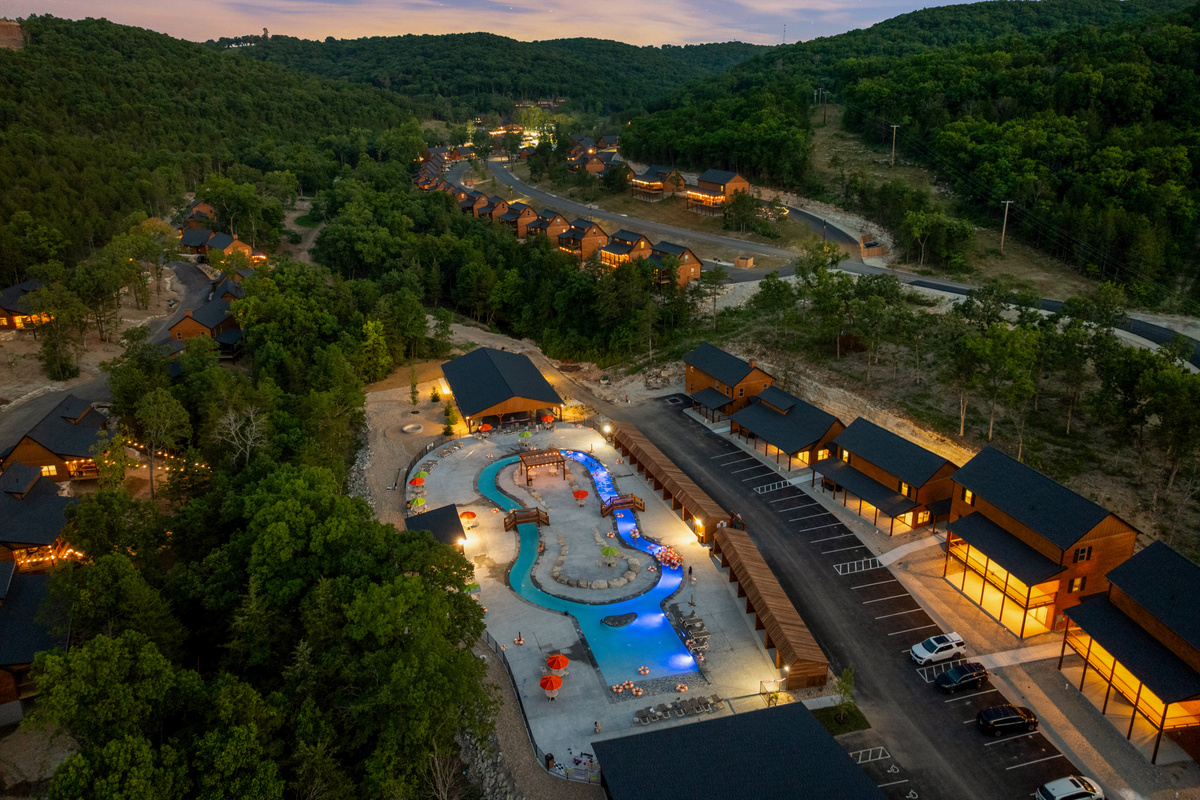 The Tall Timbers Camp lazy river and pools light up electric blue at night, just down the hill from Lone Star Lodge.