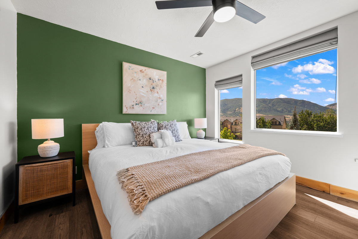Large windows fill this comfortable King bedroom with light and views of the surrounding mountains.