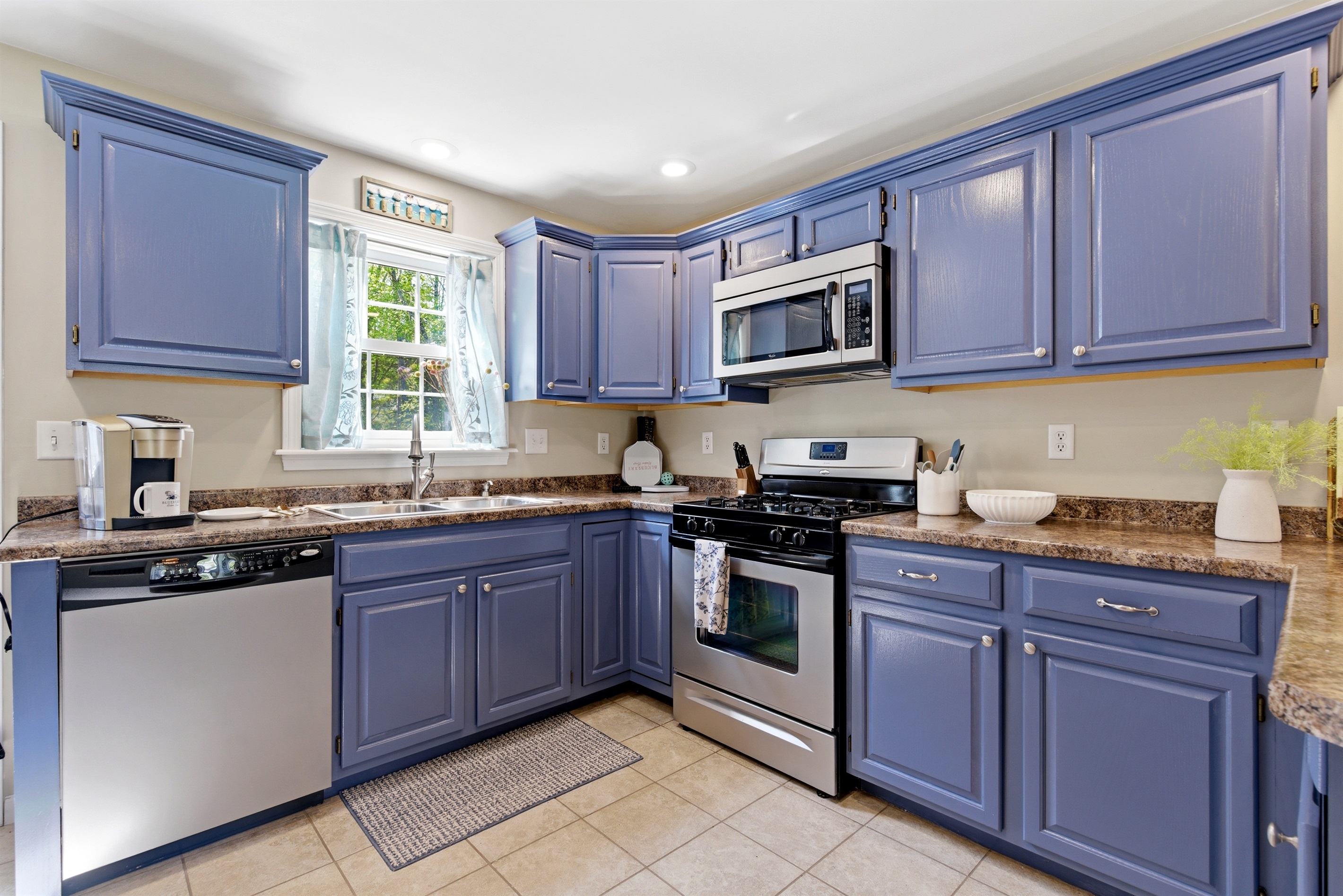 A charming kitchen featuring beautiful blue cabinetry, creating a fresh and inviting space for cooking and gathering.