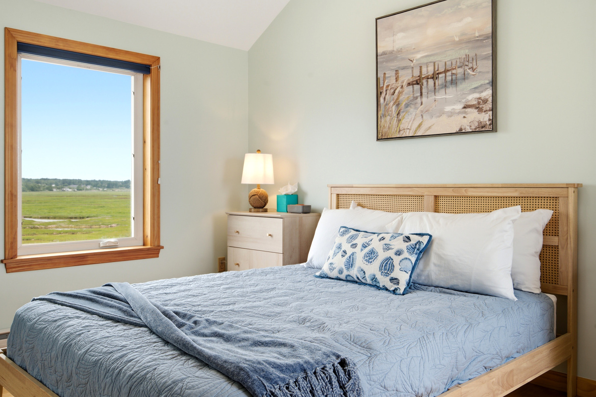 Comfortable queen bedroom with peaceful marsh views and coastal-inspired décor.