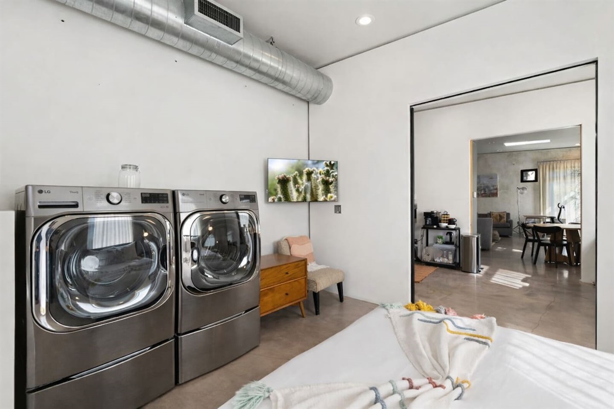 Contemporary bedroom with in-room washer and dryer, clean modern finishes, and an open flow to the living area.