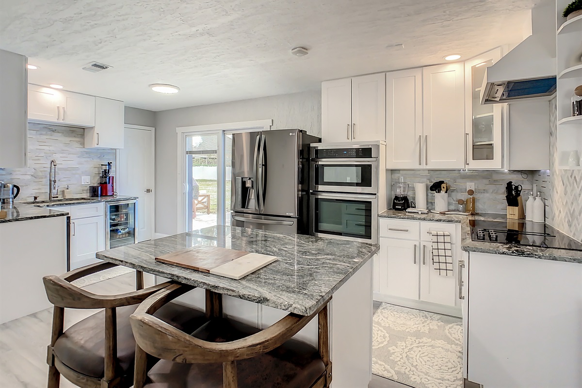 Contemporary kitchen with granite island, stainless steel appliances, and ample cabinet space.