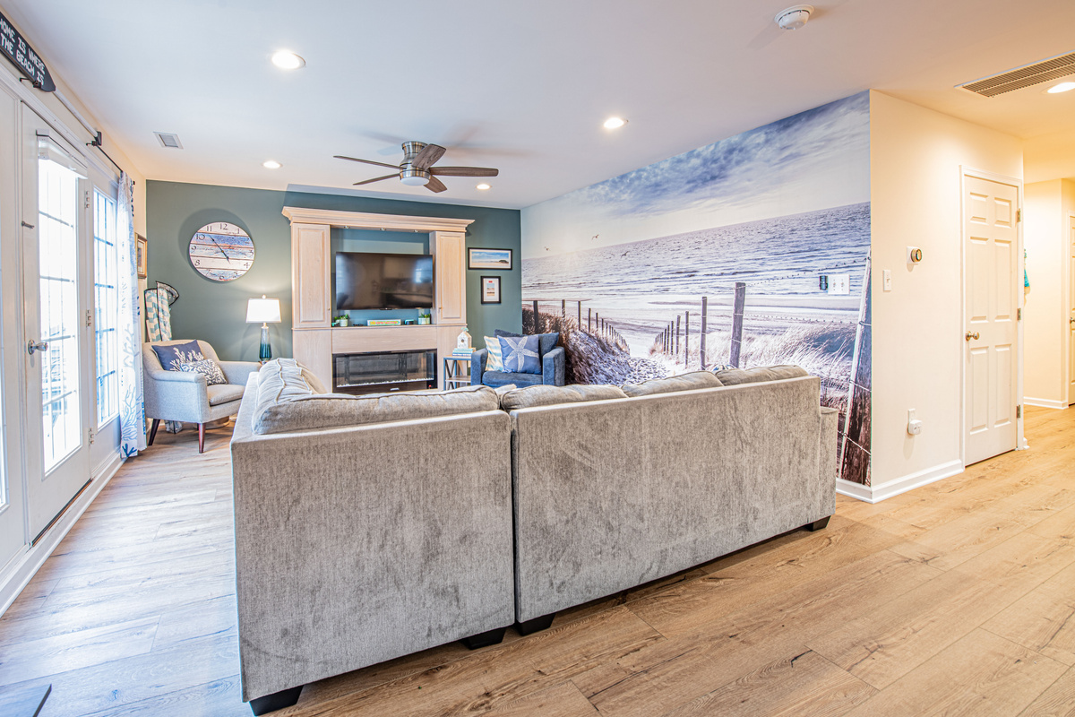 Living Room Featuring Sectional Sofa, Beach Wall Mural, and Entertainment Center
