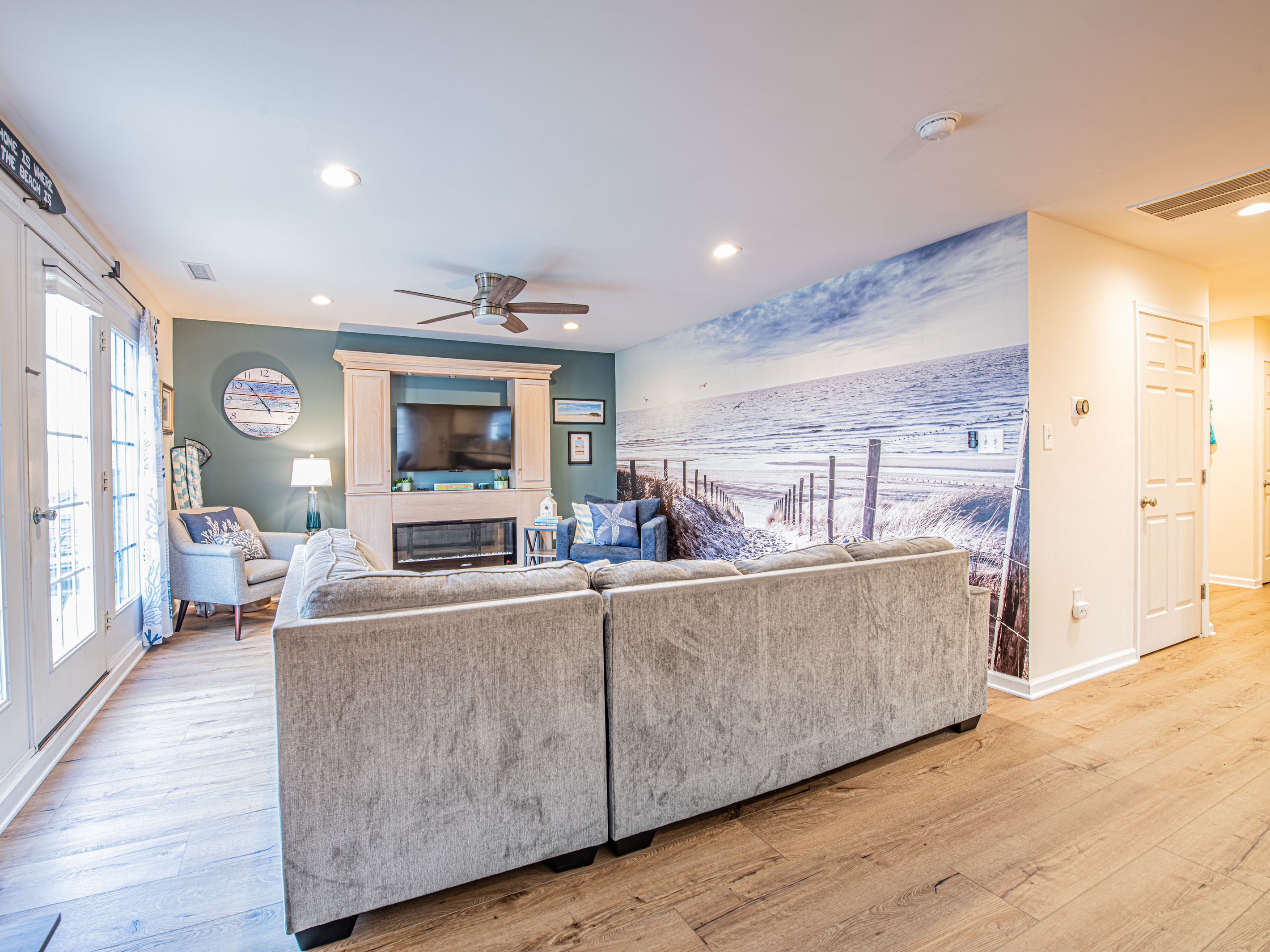 Living Room Featuring Sectional Sofa, Beach Wall Mural, and Entertainment Center