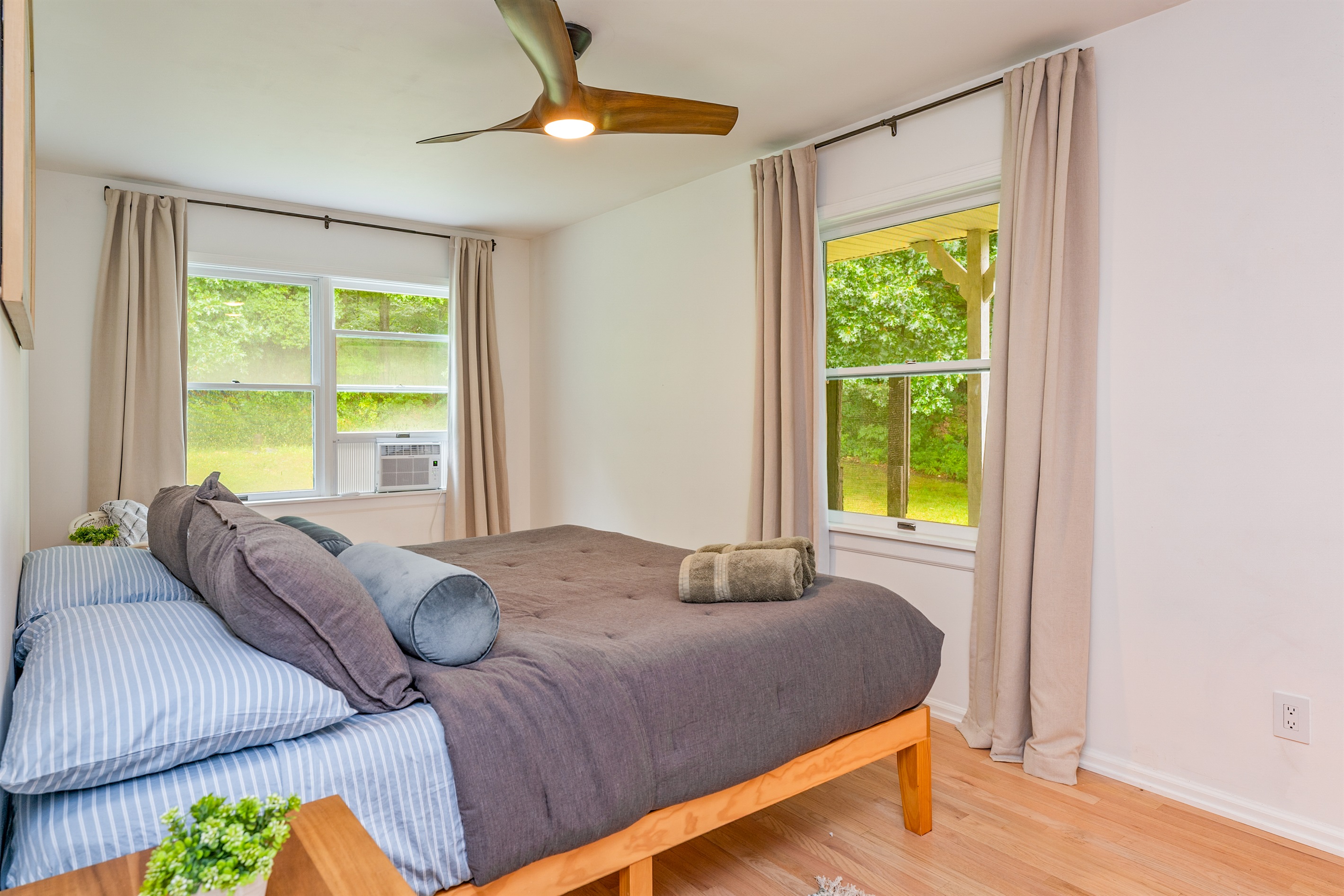 Relax in this serene king bedroom with large windows and plush bedding—your perfect escape after a day of Finger Lakes adventure