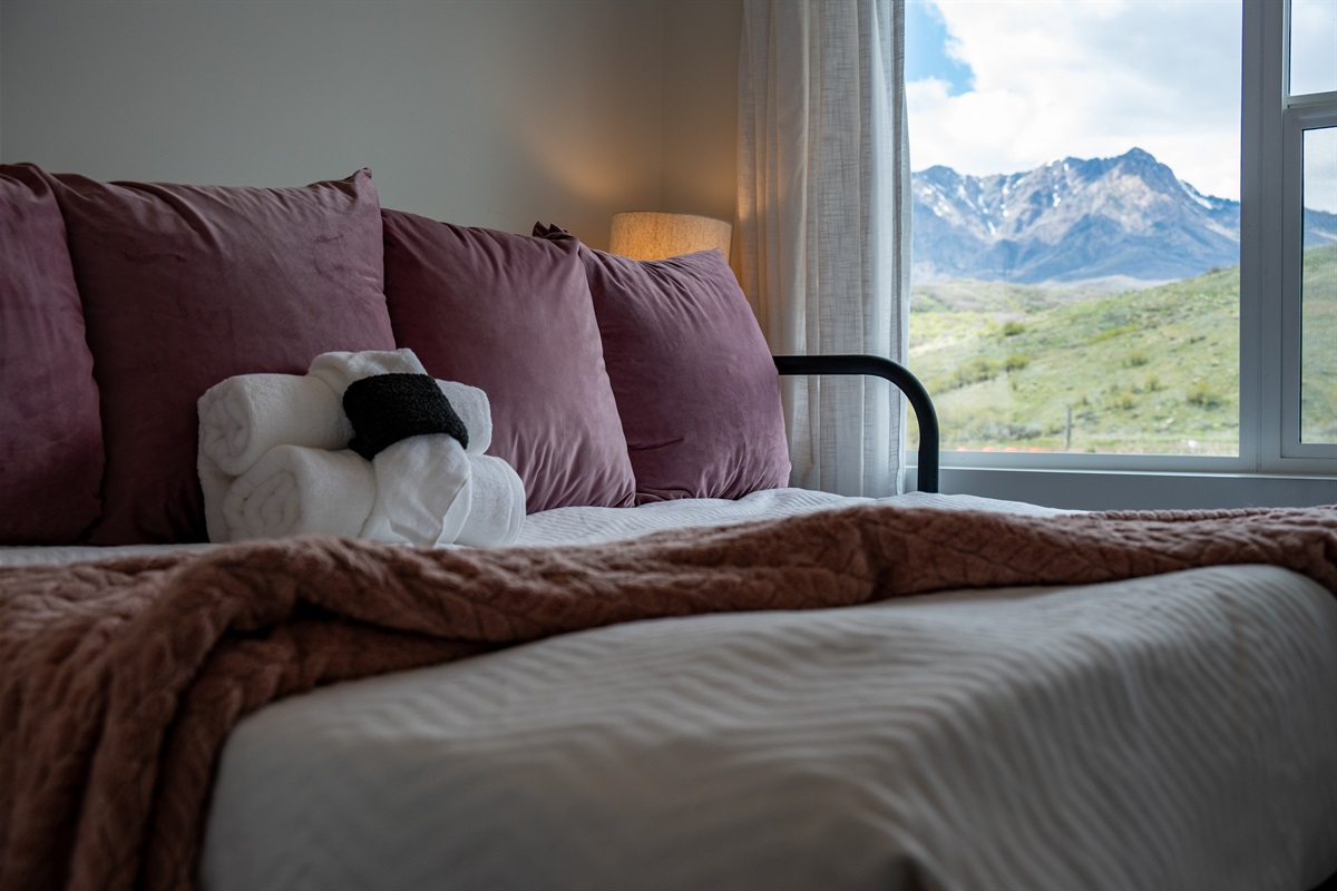 Cozy bedroom with plush bedding and stunning mountain views just outside your window