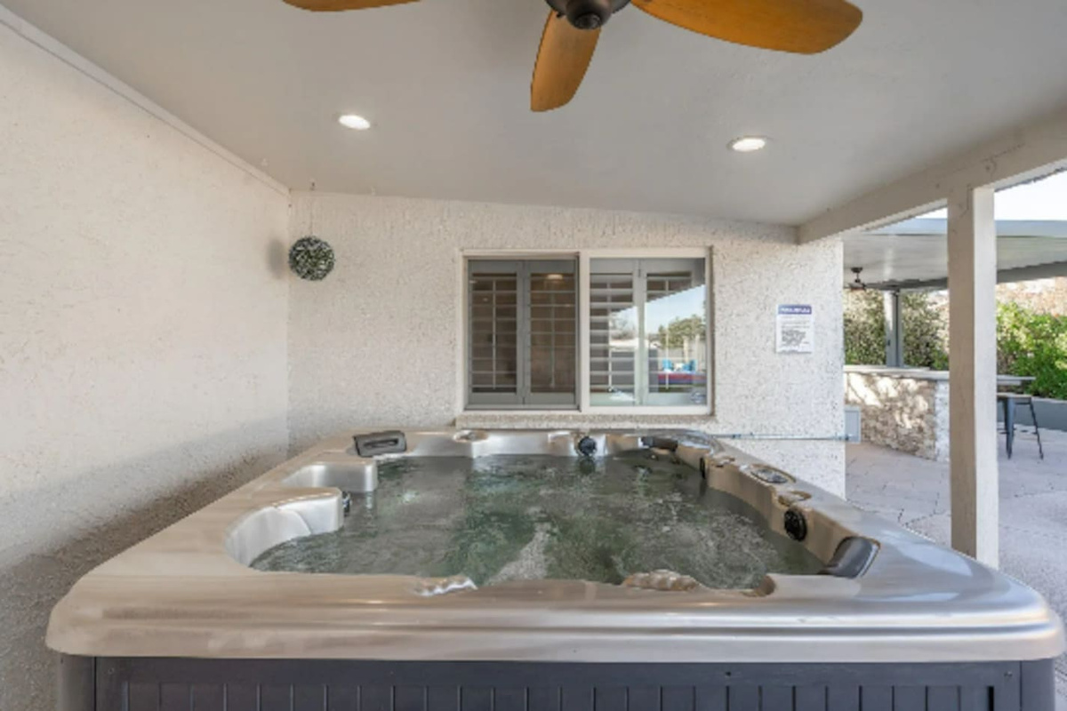 Tucked under a covered patio, this hot tub stays comfortable rain or shine, with ceiling fans keeping the air moving on warm days.
