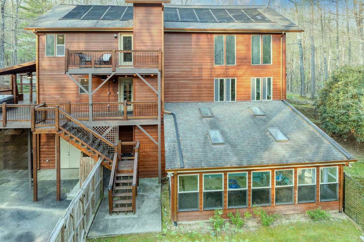 View of back of the house showing huge indoor pool, deck and fenced back yard