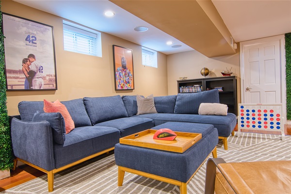 Large lounge sofa in lower floor suite with 65" TV, in-ceiling speakers