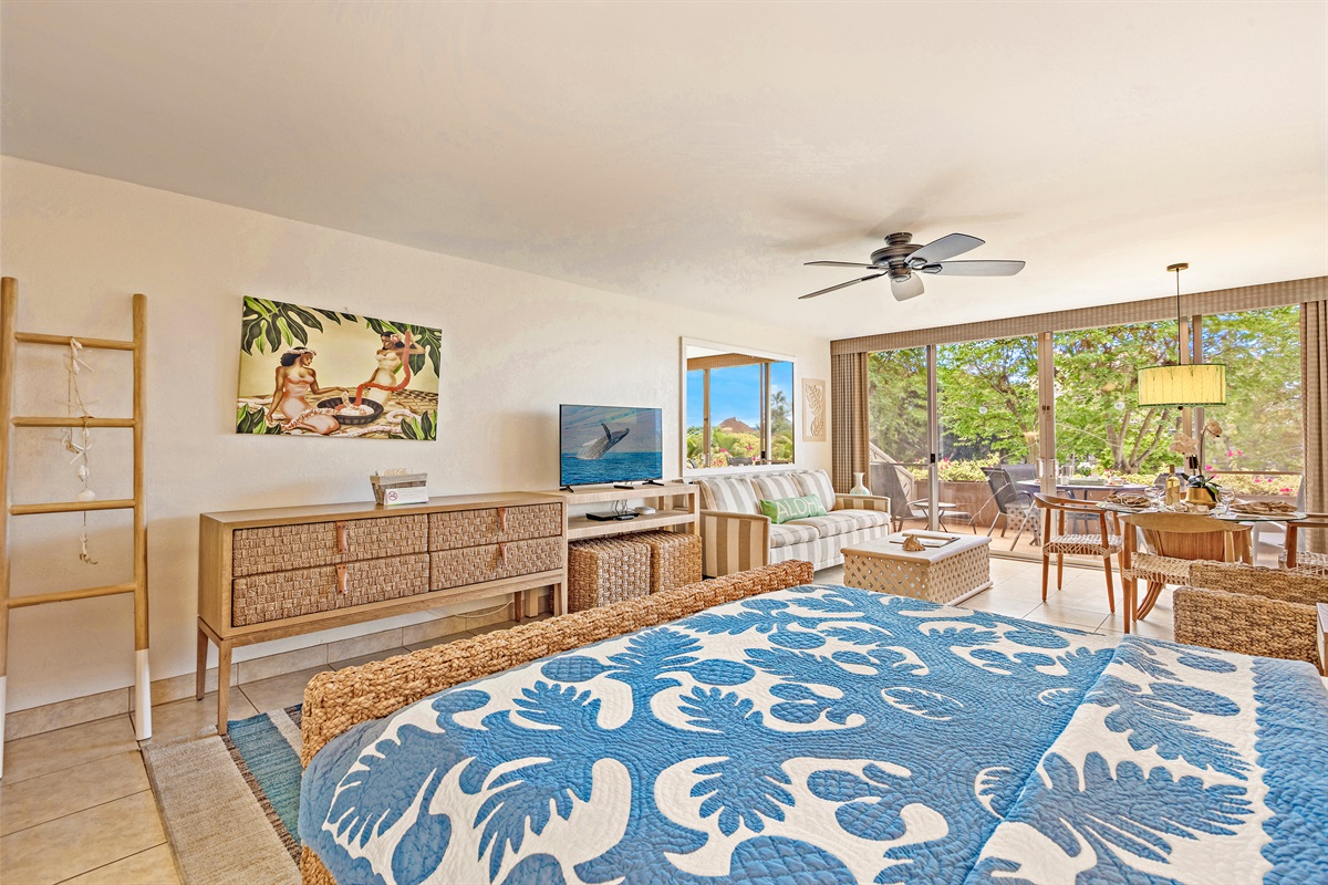 Open-concept studio layout with wicker accents and tropical artwork