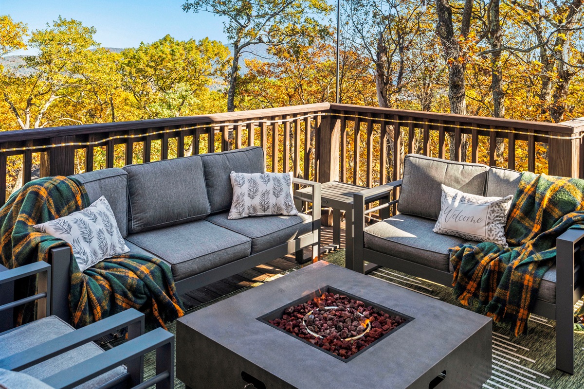 Warm autumn light filters through the trees—gather by the fire table, breathe in the cool mountain air, and unwind in plush seating with a view