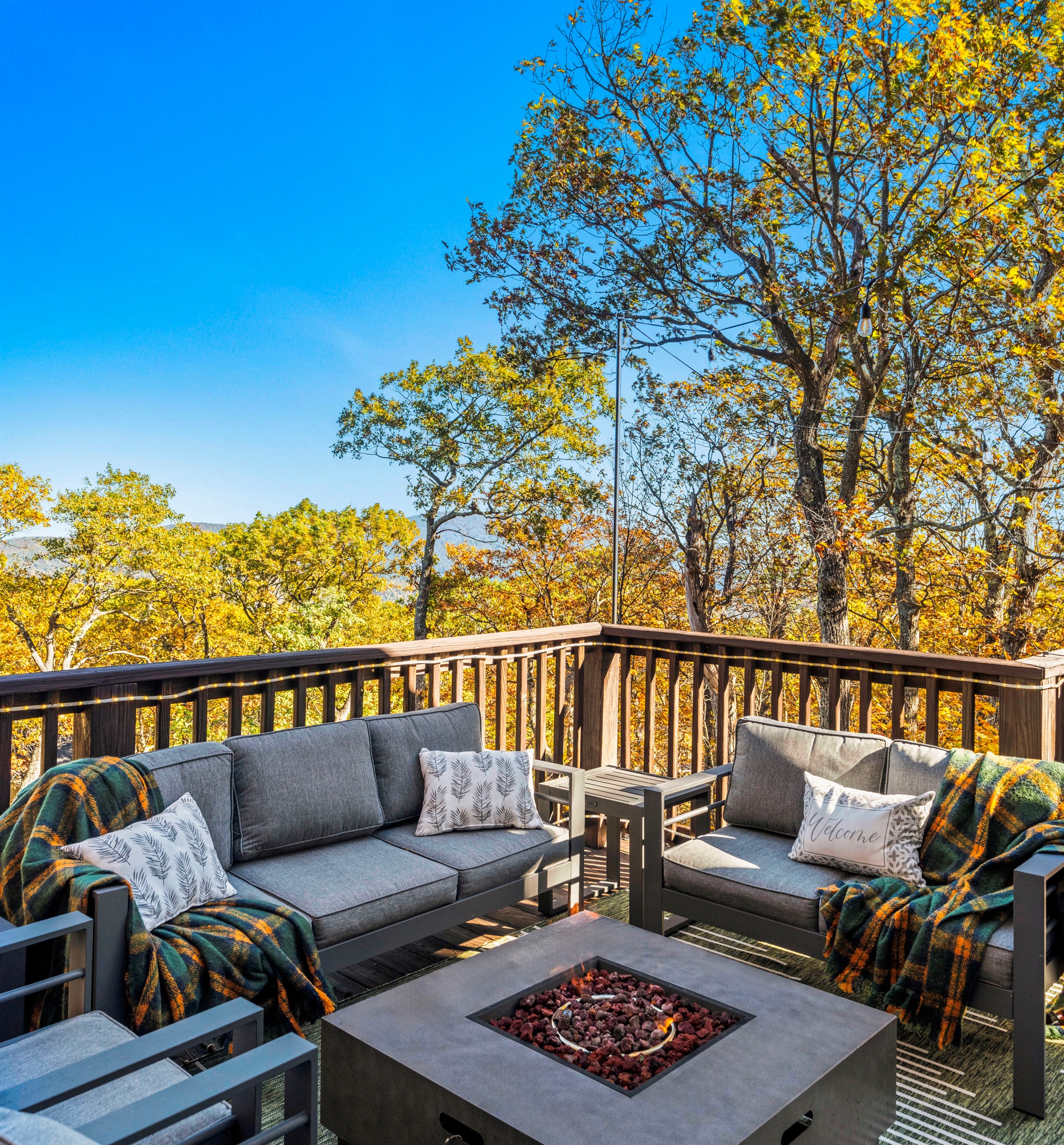 Warm autumn light filters through the trees—gather by the fire table, breathe in the cool mountain air, and unwind in plush seating with a view