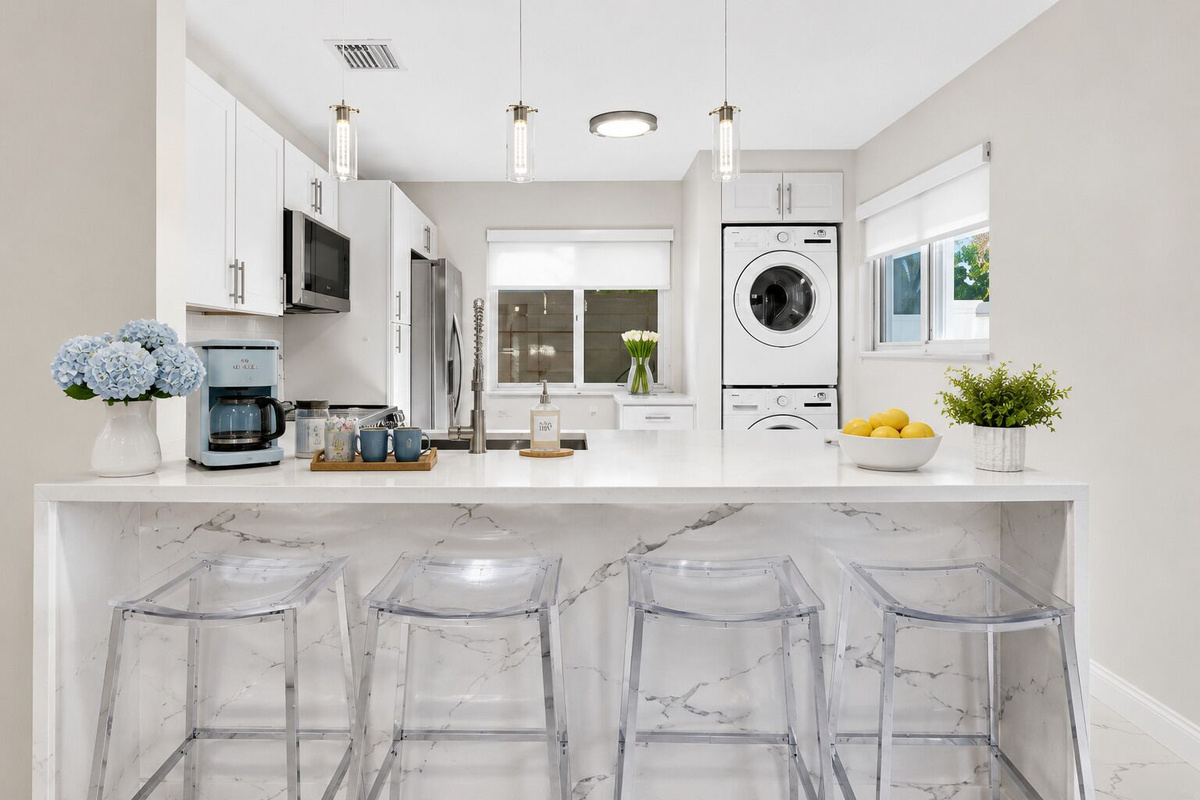 Modern, fully equipped kitchen with LG appliances, generous counter space, breakfast bar seating for four, coffee maker and convenient in-unit washer and dryer.