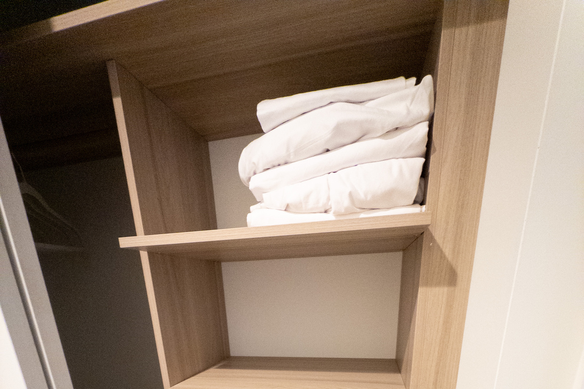 Spa-style touches - fresh towels and robes stocked on custom shelving, hotel-ready.