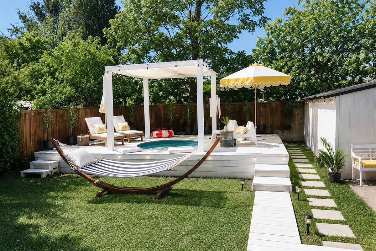 Relax in your own private outdoor oasis with spa pool, designer loungers, hammock, and lush landscaped yard
