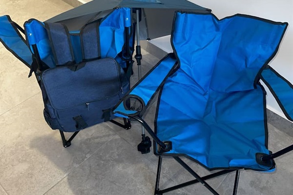 Discover backpack beach chairs, a convenient umbrella, and a backpack cooler in the laundry room, neatly stored above the washer and dryer.