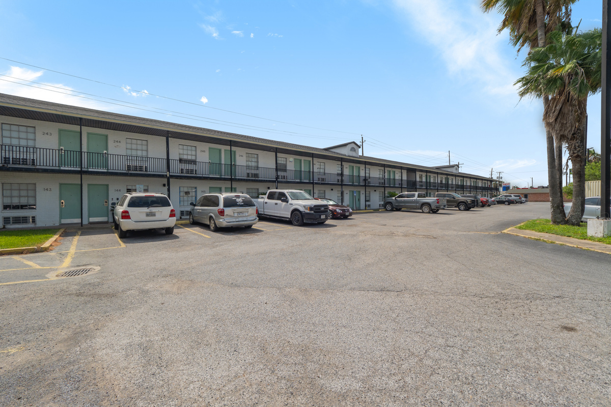 Apartment complex exterior with open parking and easy ground-level access to the units.
