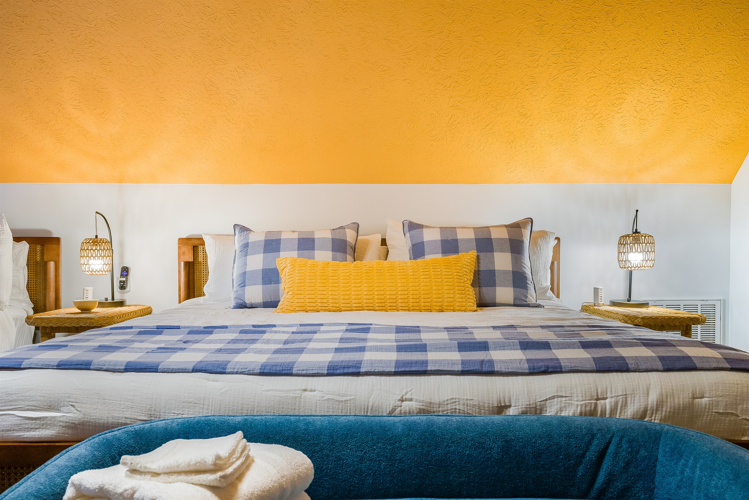 A cozy detail shot of one of the king beds, showcasing the vibrant bedding, soft pillows, and inviting atmosphere—ready for a restful night’s sleep.