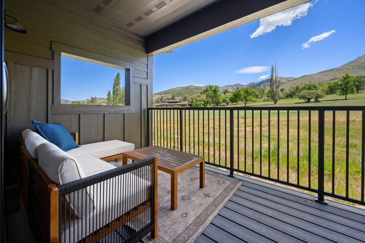 Private covered balcony with comfortable outdoor lounge seating.